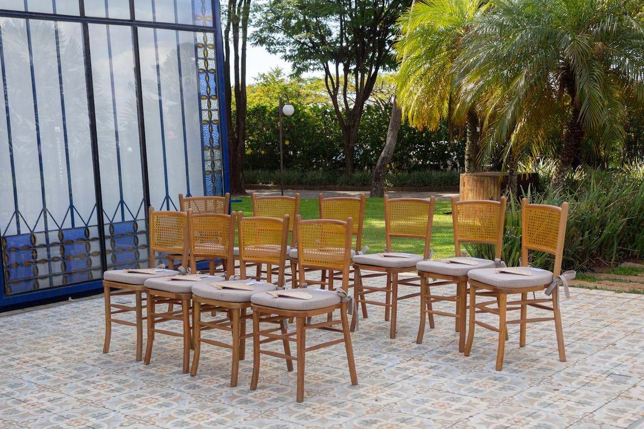 Arrangement of wooden chairs for an outdoor event in São Paulo, Brasil, under palm trees.